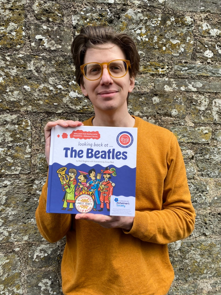 Simon Reid holding a copy of looking back at...The Beatles